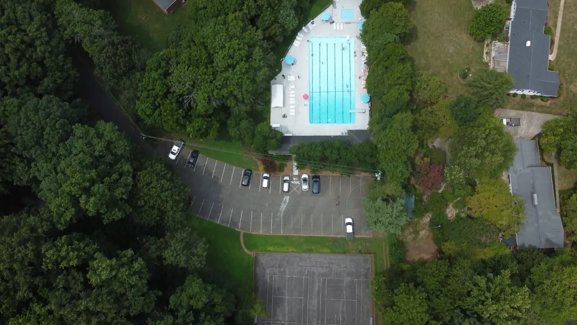 Aerial view of a community swimming pool surrounded by trees