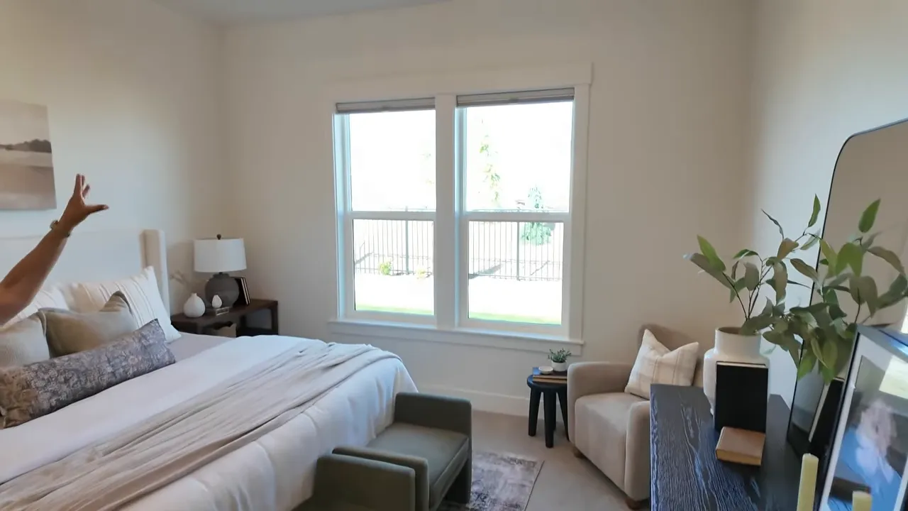 Primary bedroom with tray ceiling chandelier bed and double windows