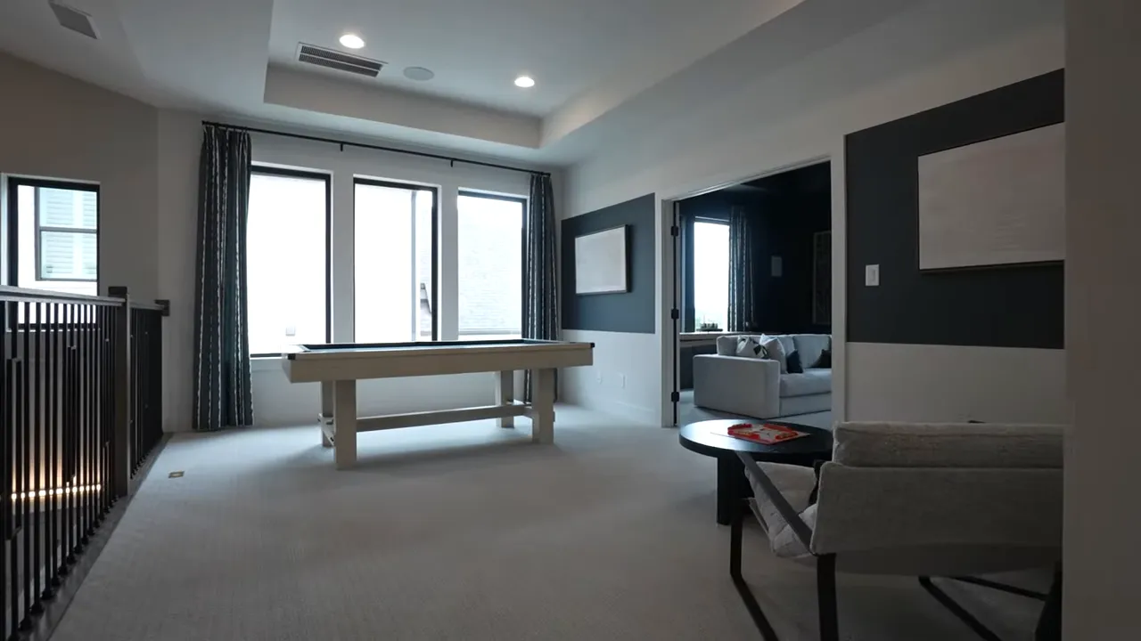 Bright modern living room with large windows and dark accent wall in Palmera Ridge Leander TX home