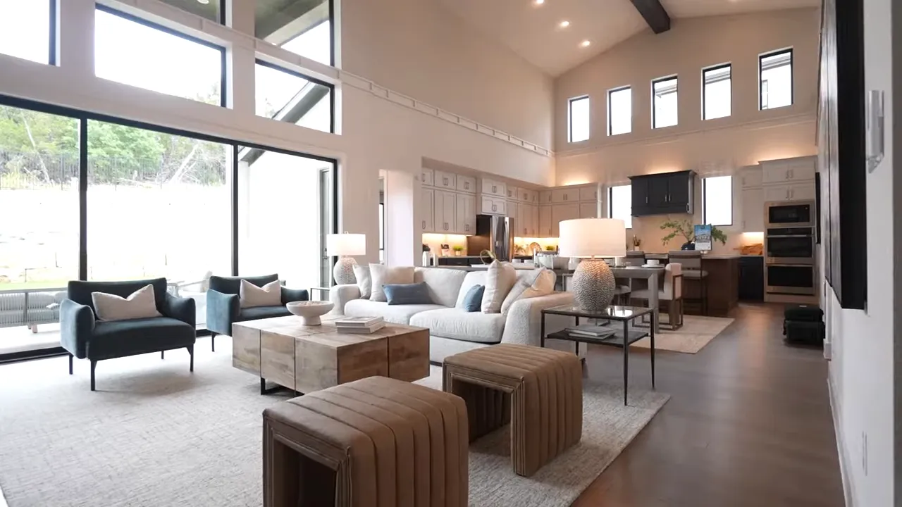 Palmera Ridge home interior screenshot showing an open-concept living room with kitchen and tall windows