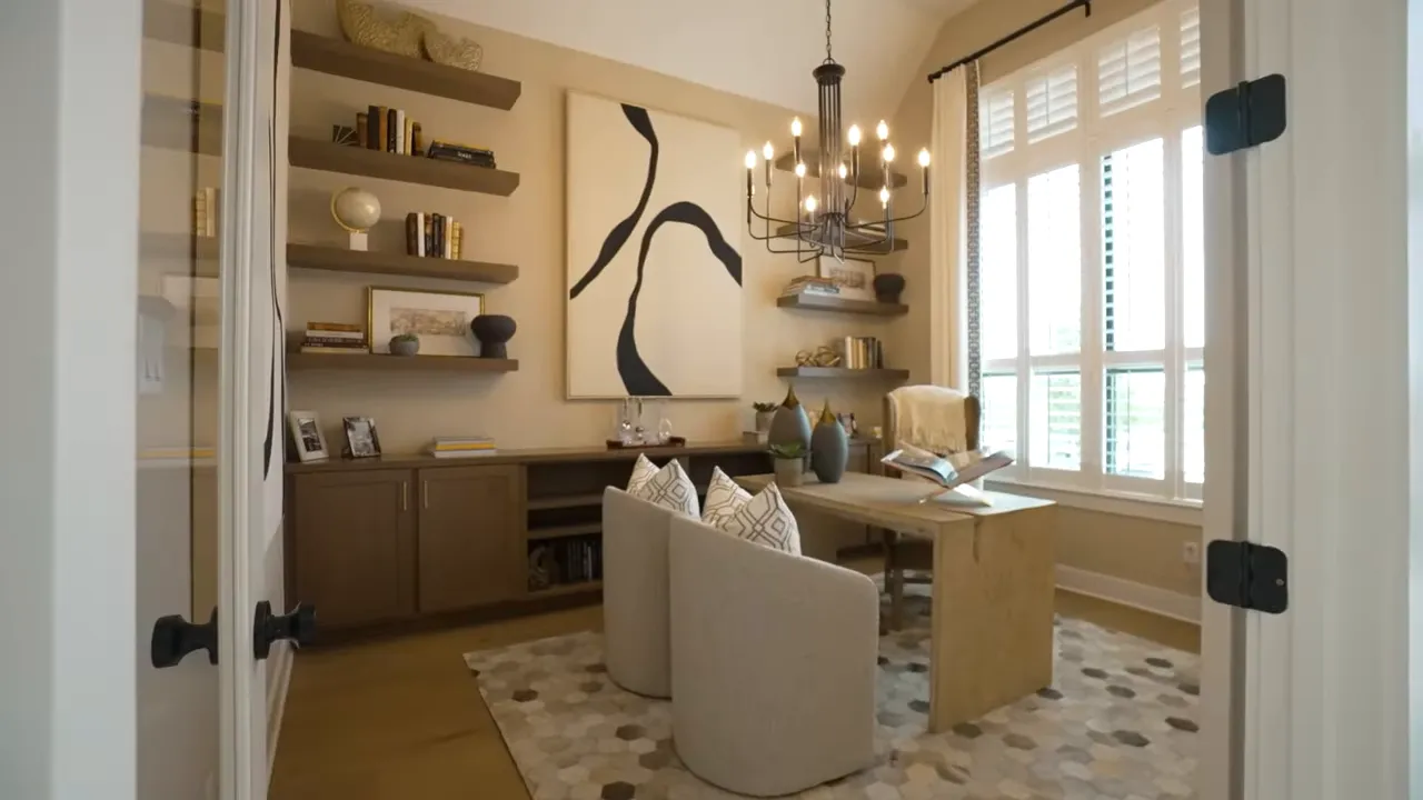 Study with desk chandelier shelving and large front windows