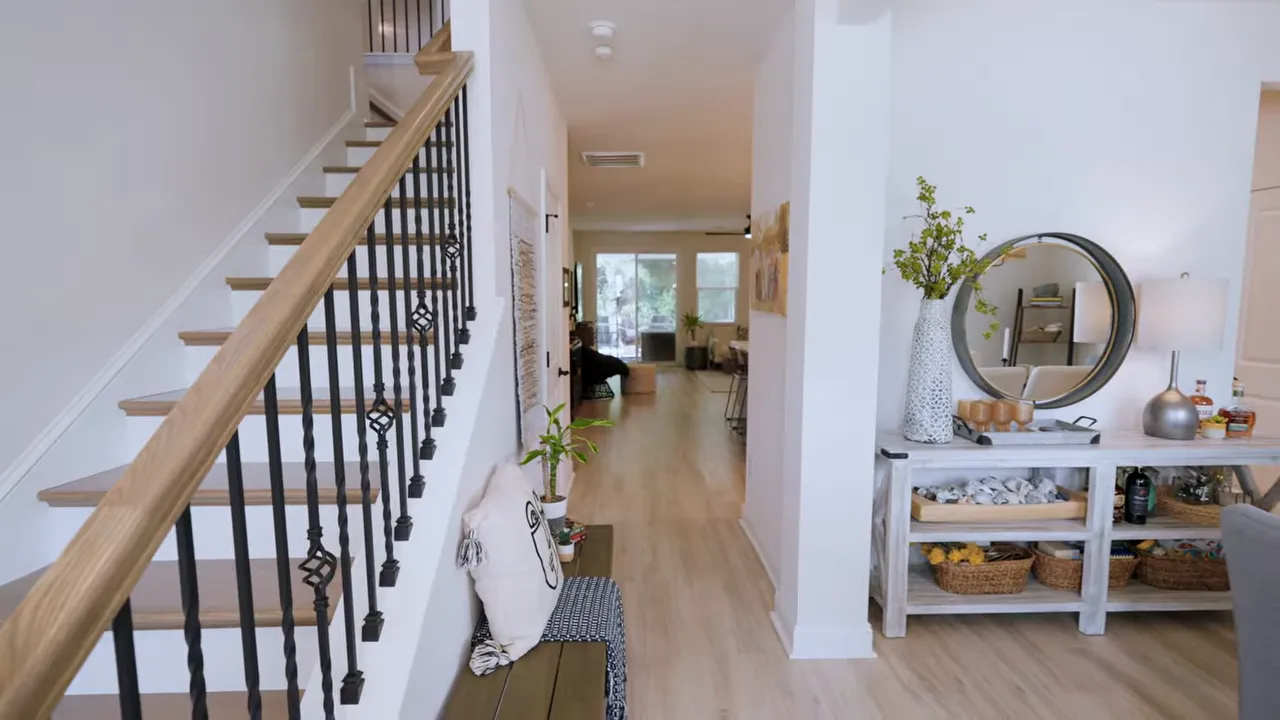 Entry hallway with hardwood staircase dining room and light wood flooring