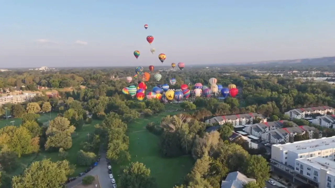 Aerial view of an Idaho valley with many hot air balloons over a community event