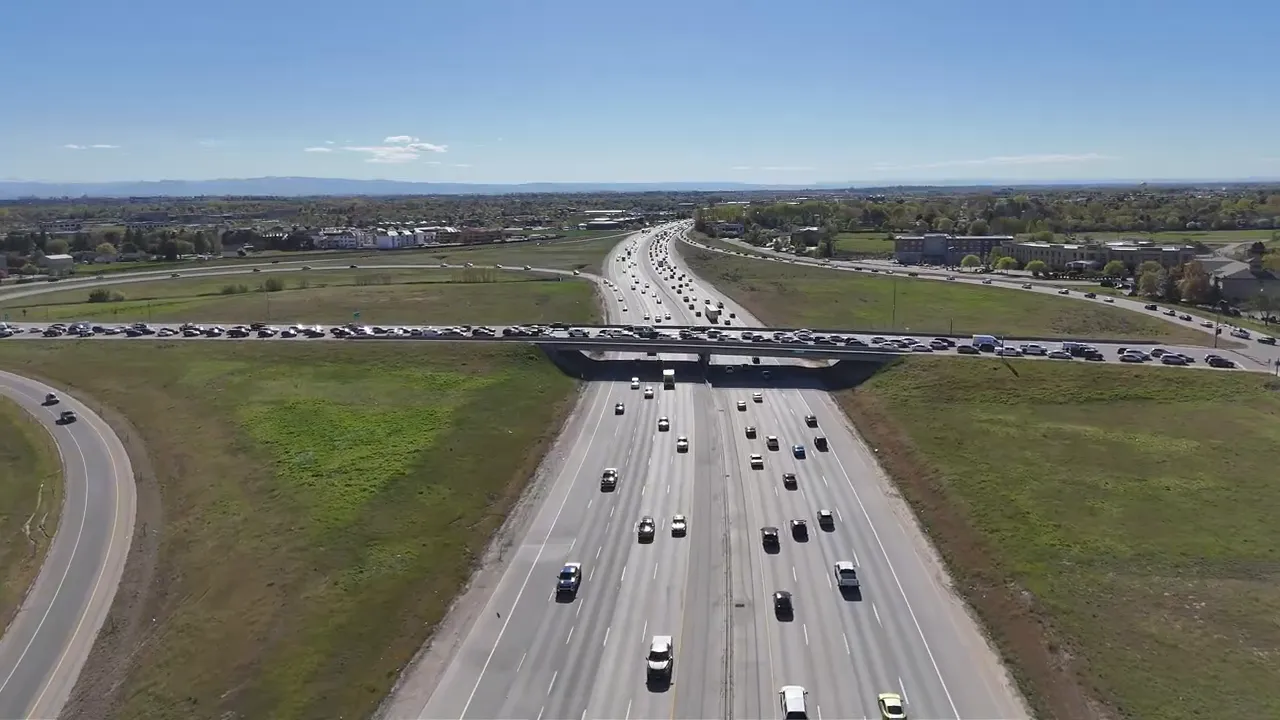 Aerial view of traffic on a multi-lane highway over a green landscape