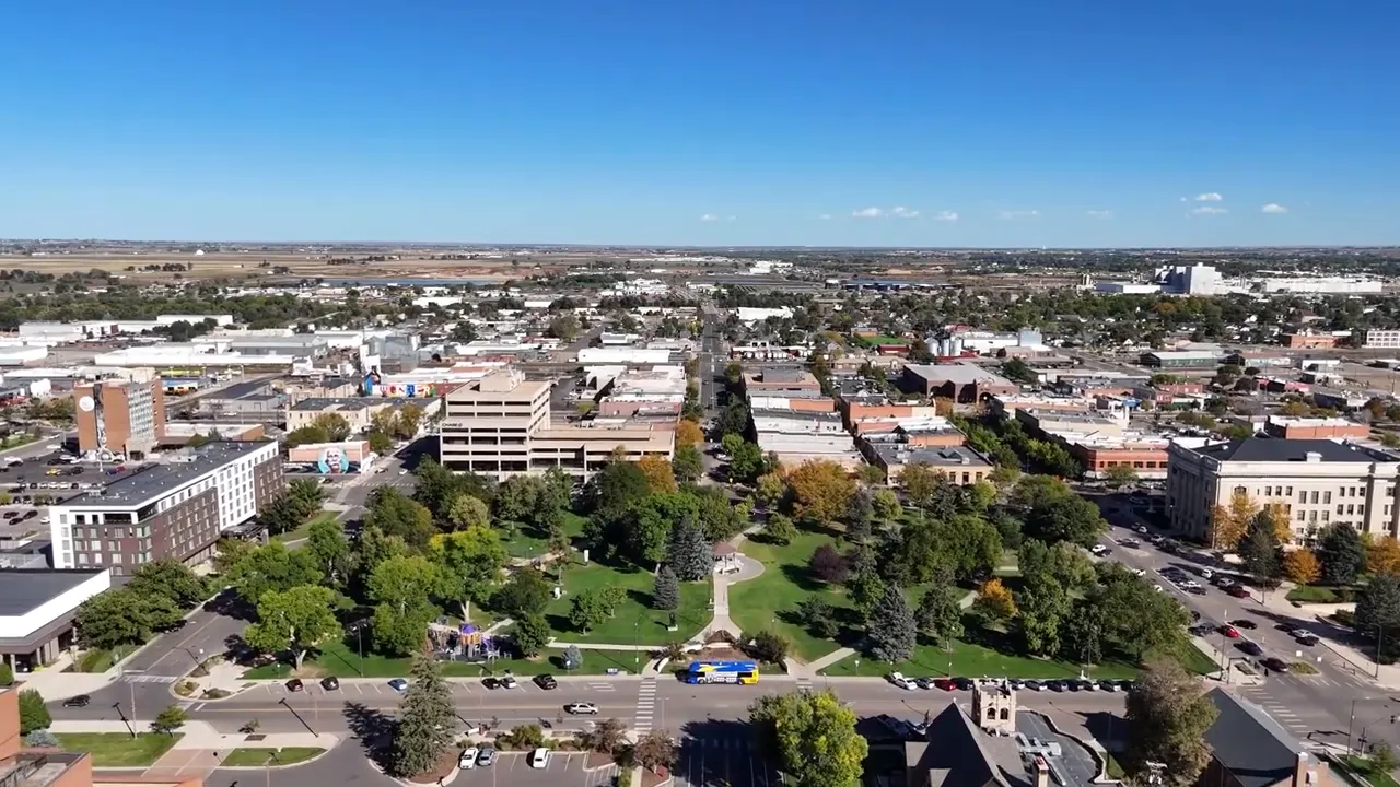 Aerial view of a Northern Colorado downtown area with central green space and roads