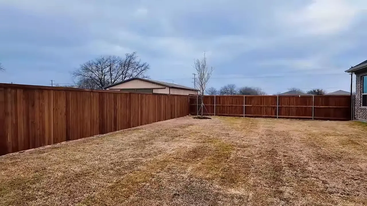 Wide view of fenced backyard in a Frisco TX new construction home