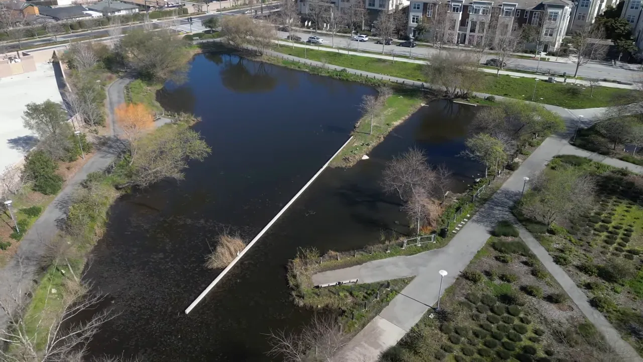 Aerial view of large Bay Meadows Park with paths and trees