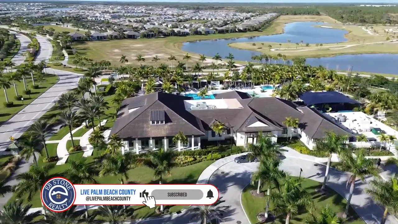 Aerial view of a Palm Beach Gardens new construction community with homes, roads, and a water feature