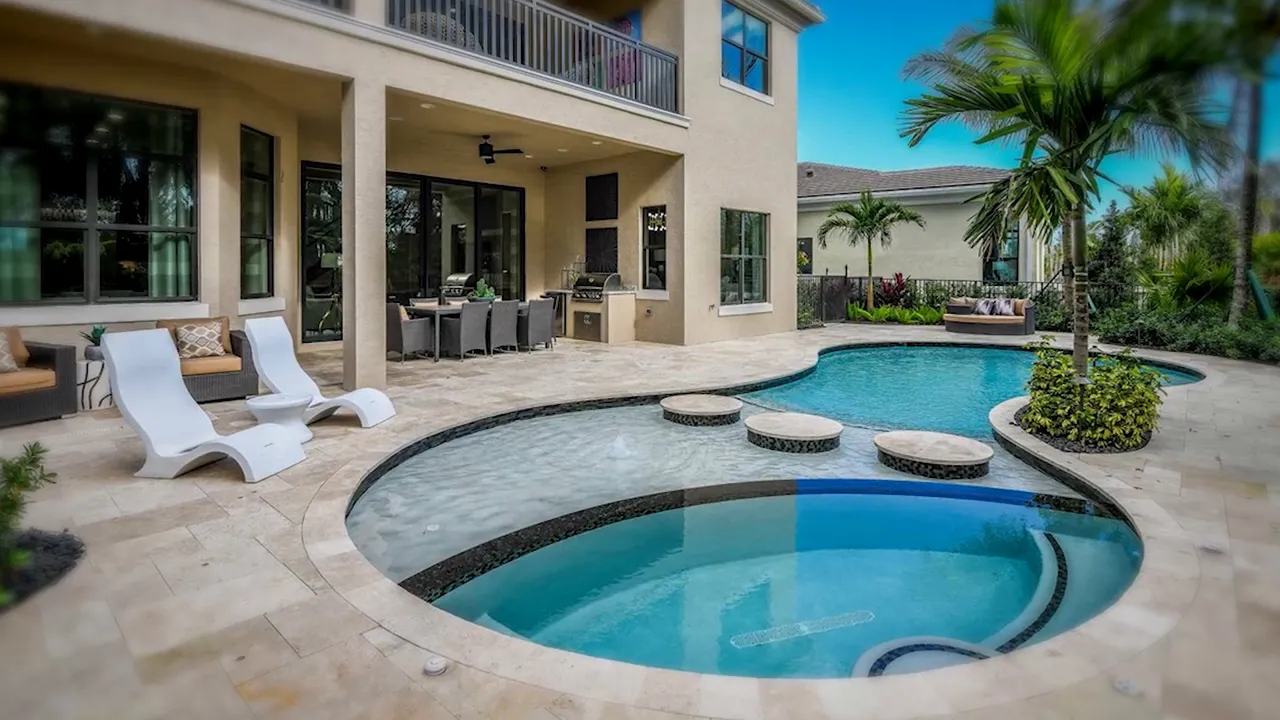 Turnkey backyard pool area with patio seating at Artistry Palm Beach