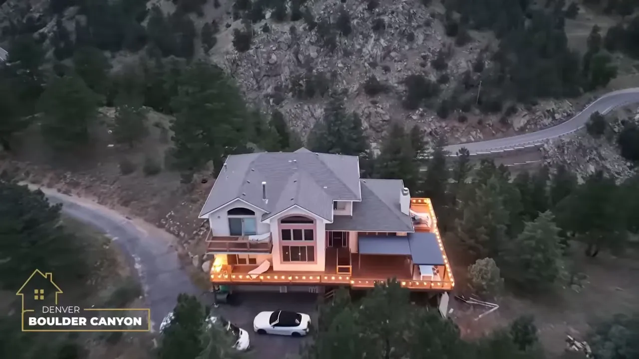 Large home in Boulder Canyon beside forested rocky hills