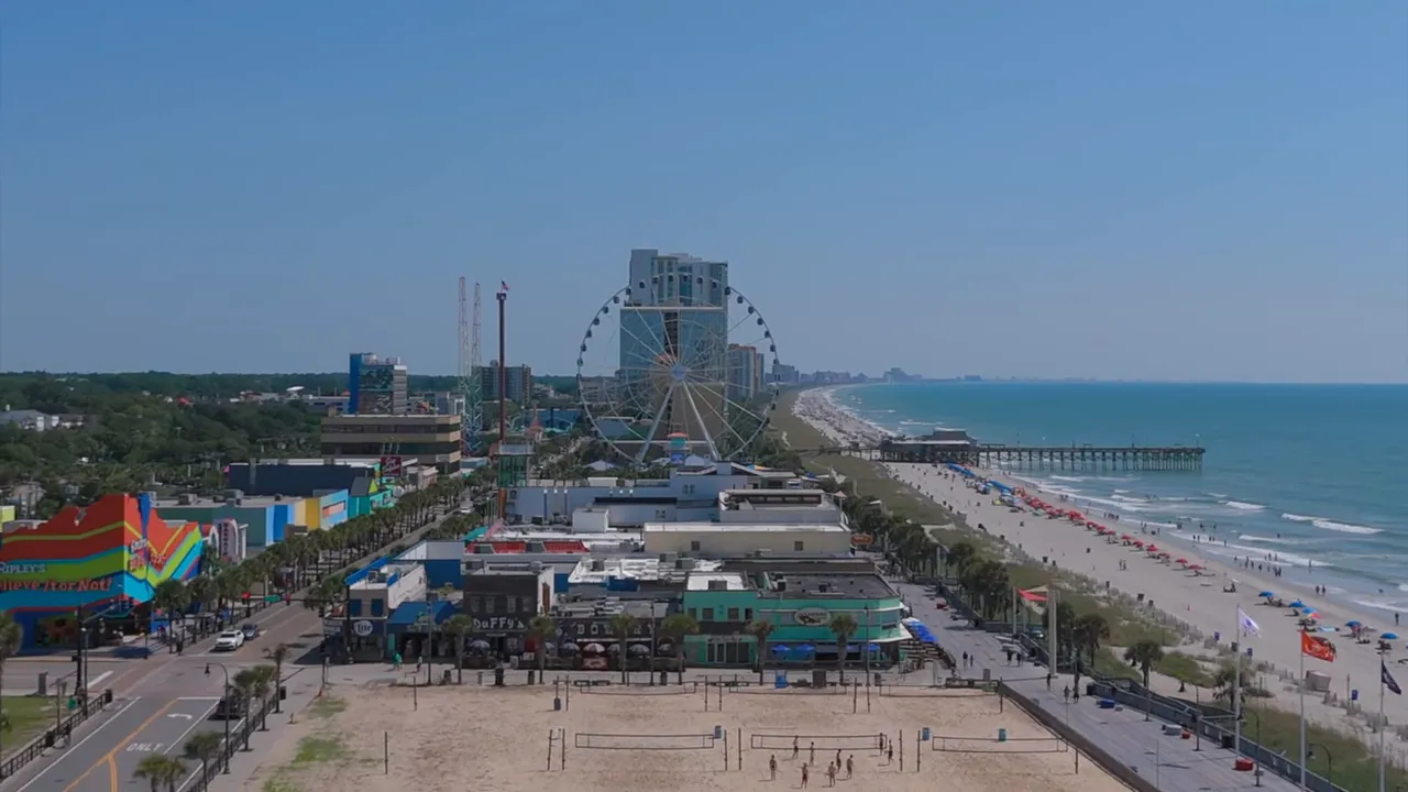 Aerial view of Myrtle Beach coastline with beachgoers and ferris wheel