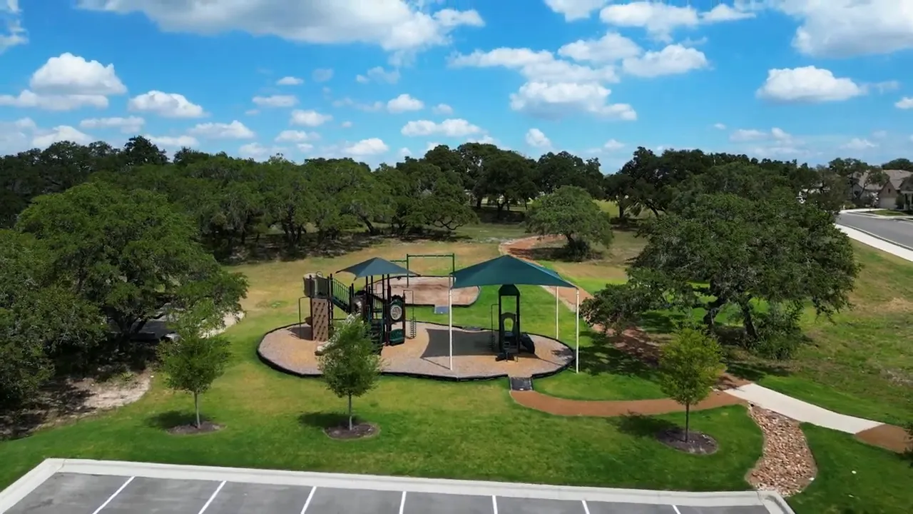 Aerial view of neighborhood amenities with pool playground sidewalks and surrounding homes