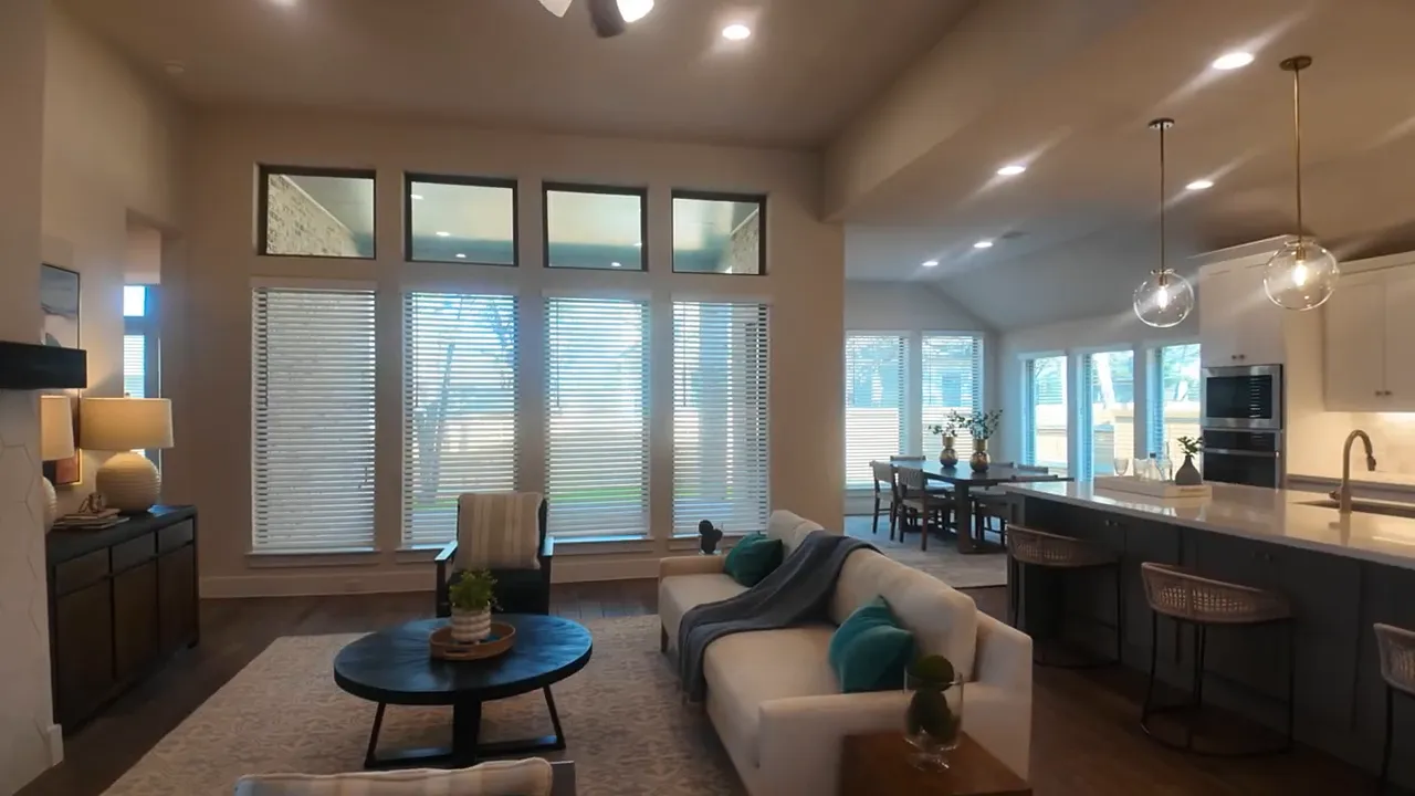 Open living room and kitchen in second house with large windows and island seating