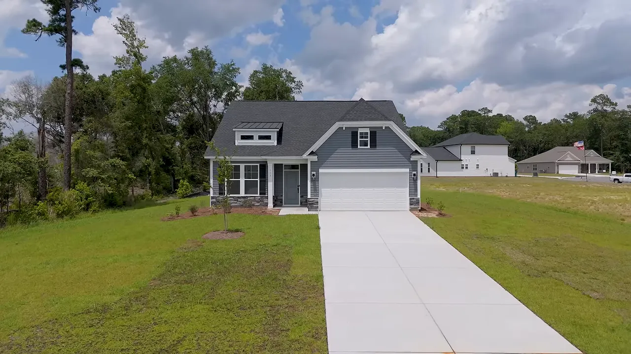 Two-story new construction home with stone accent entry and long driveway