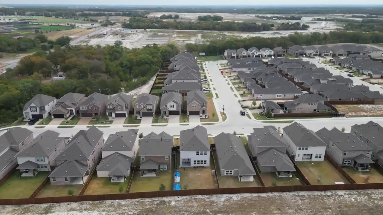 aerial view of a large new construction neighborhood with rows of homes