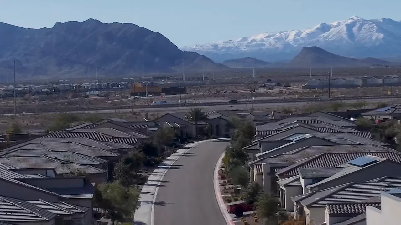 Wide aerial view of Trilogy Sunstone neighborhood streets and rooftops with mountains