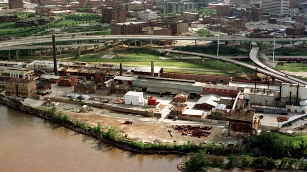 Aerial photograph of industrial smelting site and riverfront with adjacent highway
