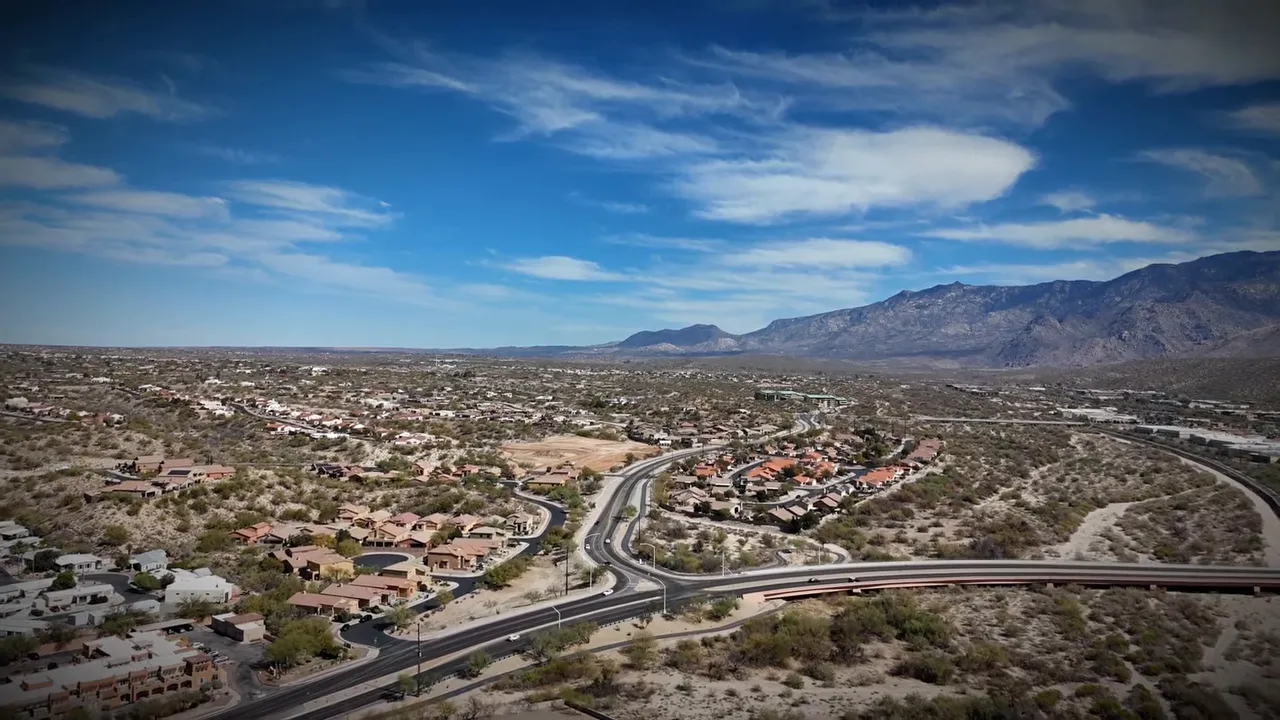 Aerial view of suburban homes and roads beside mountains in the Tucson area