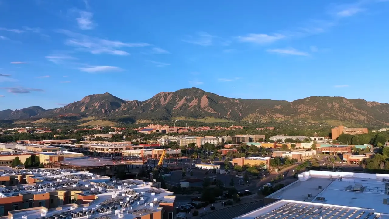 Aerial view of Louisville Colorado skyline with mountains and businesses in the foreground