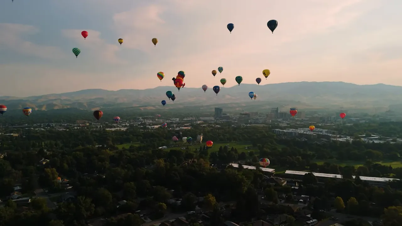 Hot air balloons floating above Boise at sunrise