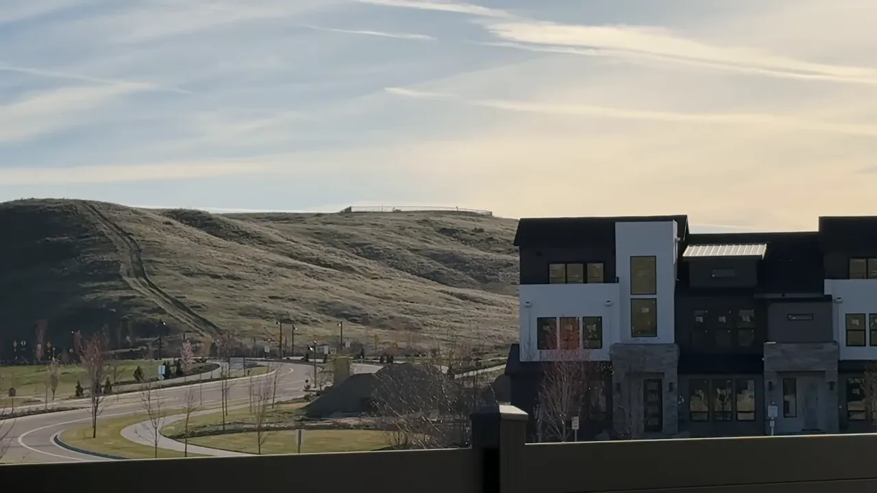 Avimor homes along a curving road with foothill landscape at sunset
