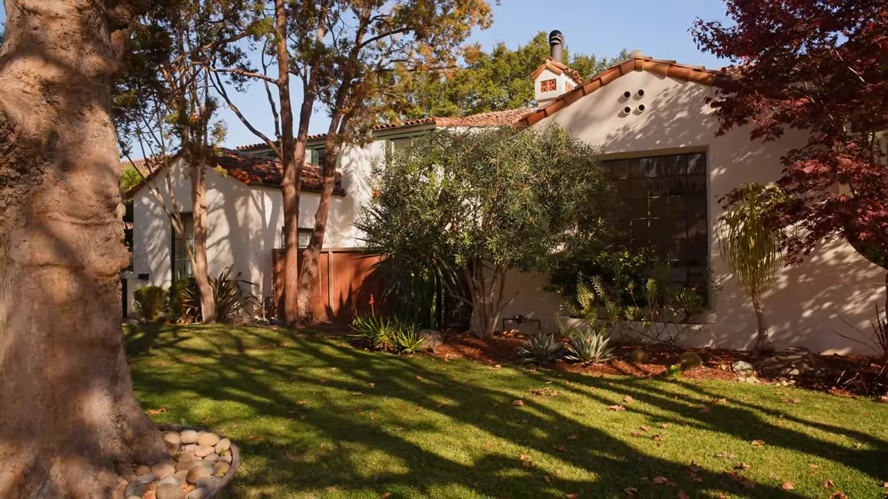 Spanish-style home front yard with manicured lawn and mature trees in Baywood San Mateo CA