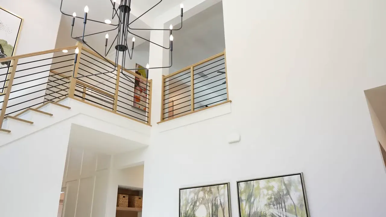 Tall open interior with staircase and ceiling lights in a Parkside On The River model home