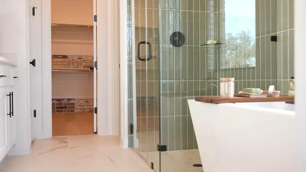 Modern glass shower enclosure with tiled walls in a Parkside On The River home bathroom