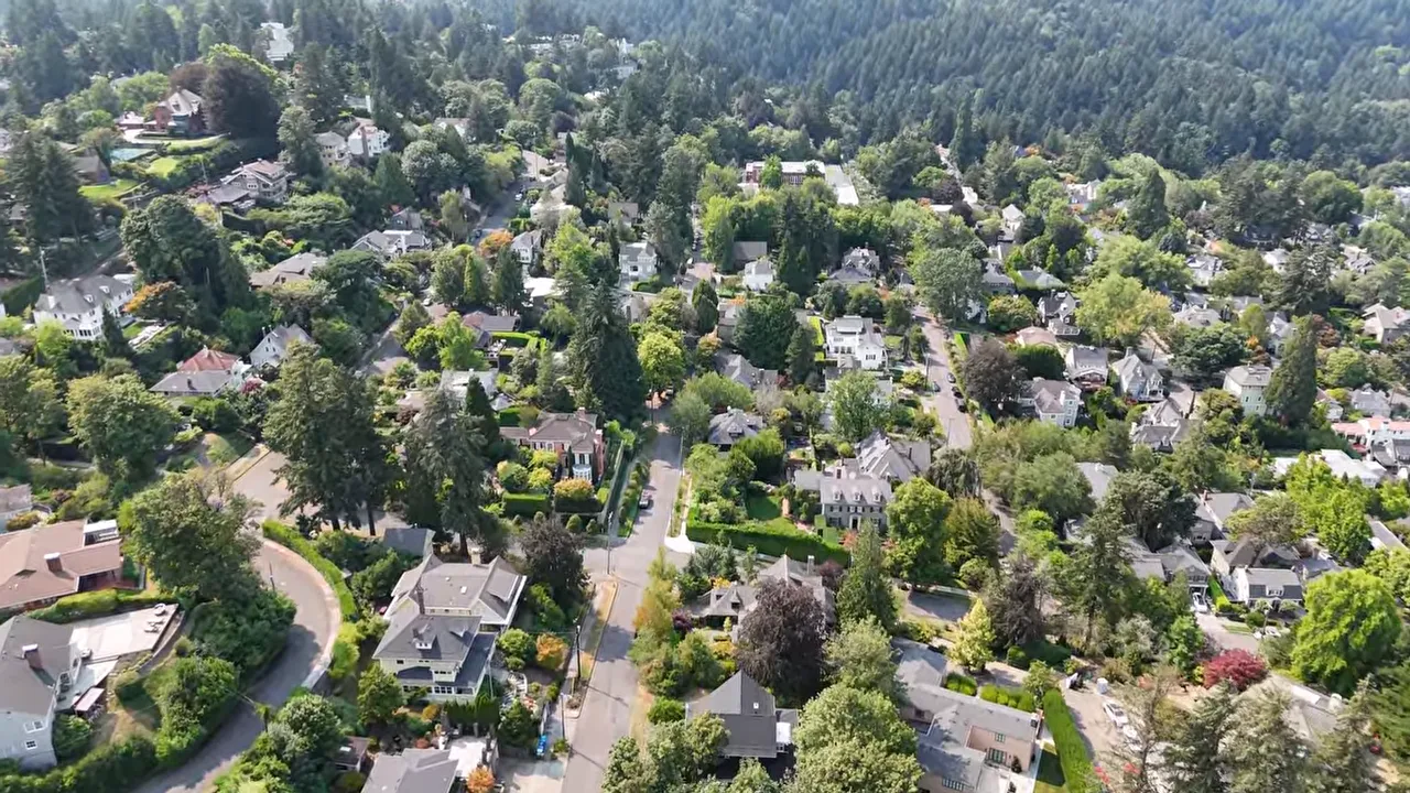 Aerial view of wooded homes with the West Hills in the background