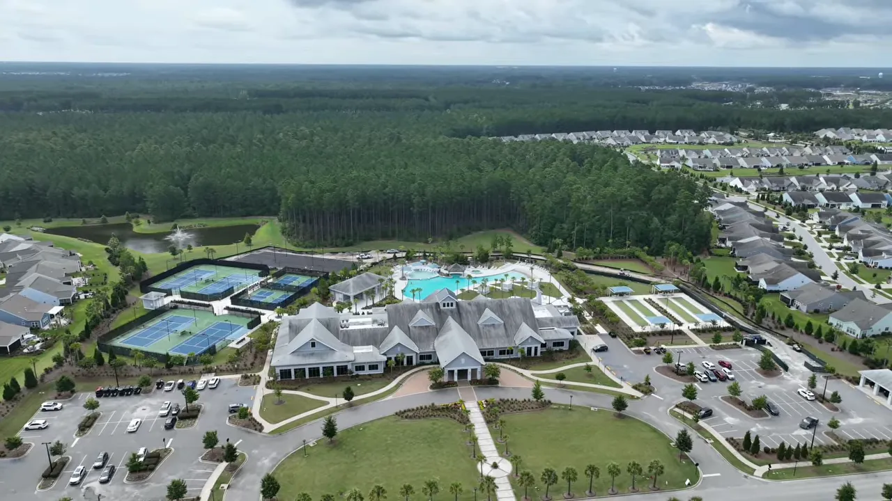 aerial view of a large amenity center with pools and surrounding homes