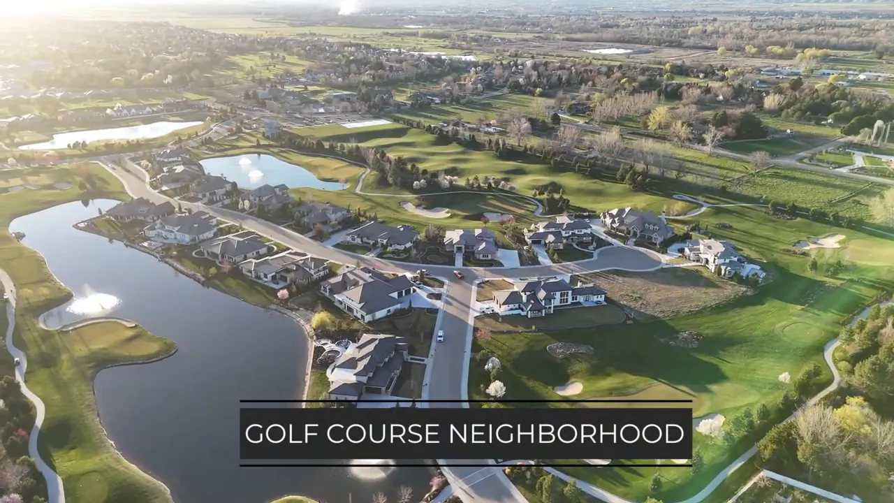 Aerial view of homes, water features, and a green golf course