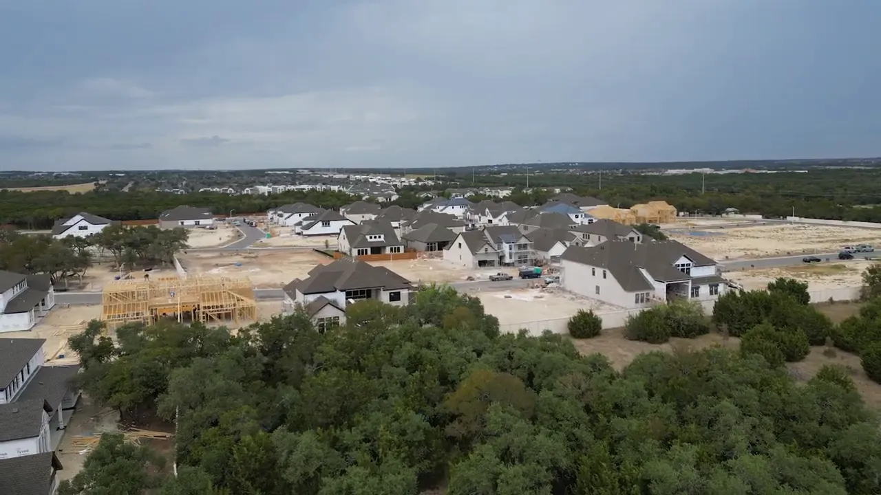 Aerial view of new homes and surrounding wooded land