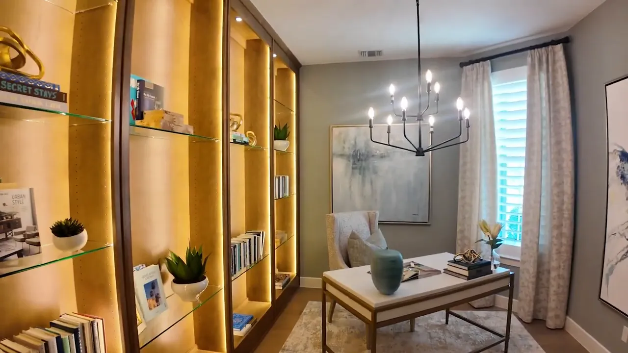 Study with desk chandelier lit built in shelves and window
