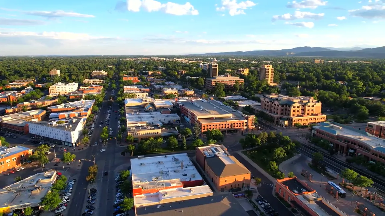 Aerial view of downtown Fort Collins with streets, buildings, and distant foothills