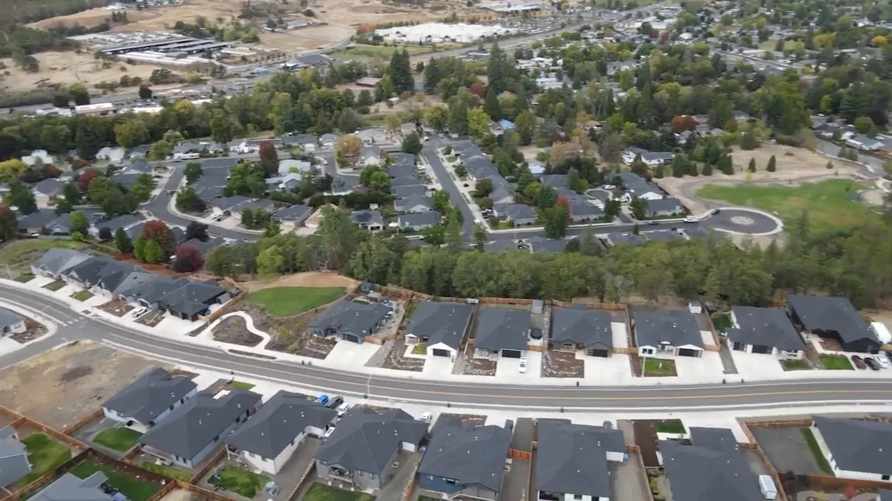 Aerial neighborhood view showing rows of new homes, streets and cul-de-sacs