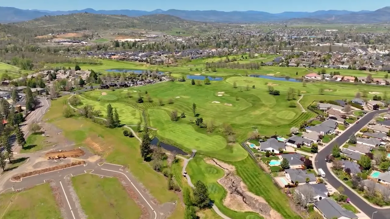 High-resolution aerial view of golf course, surrounding neighborhood and vacant development lots