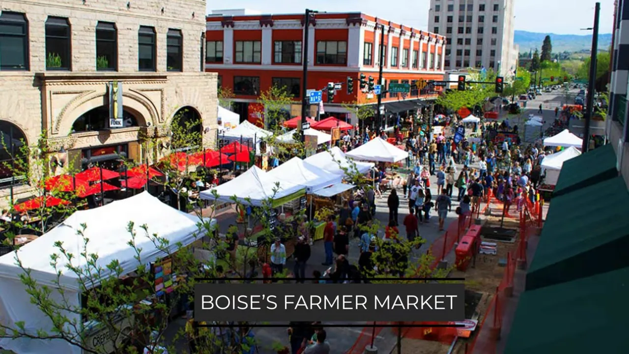 Busy downtown street market with white vendor tents shoppers and surrounding brick buildings