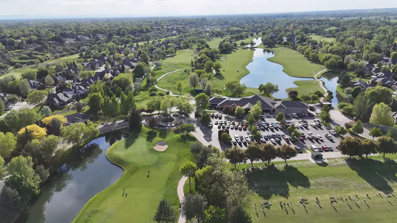 Aerial view of Eagle Idaho golf community with ponds, greenery, and parking area