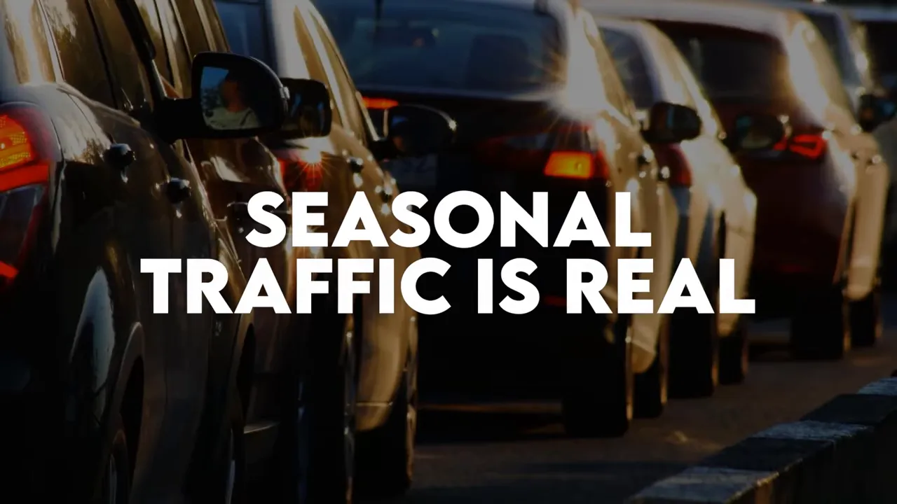 Cars in traffic with large text reading seasonal traffic is real