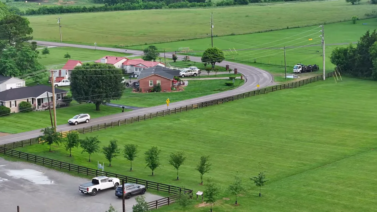 Green pasture with fencing and a country road