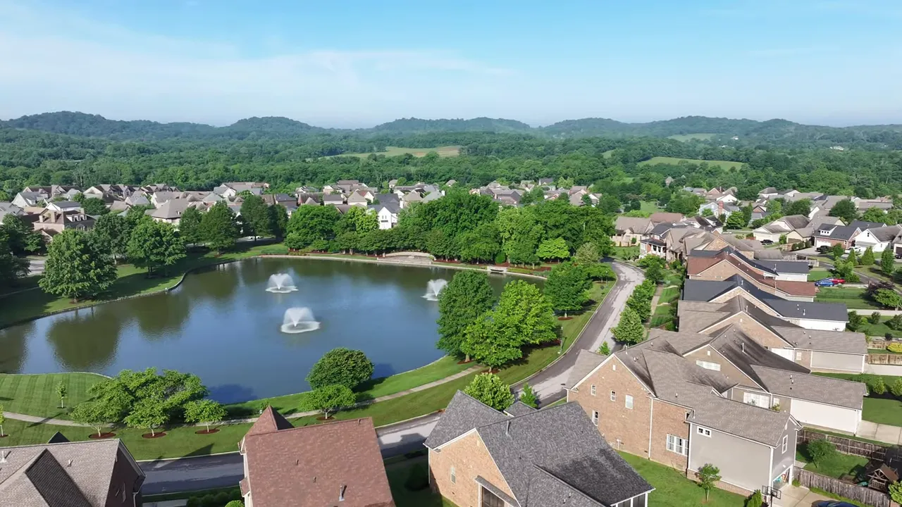 Neighborhood homes surrounding a lake with a fountain