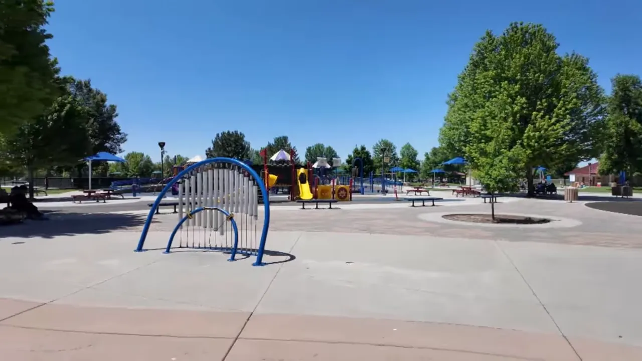 Settlers Park playground with blue and yellow play structures and benches at Meridian Idaho