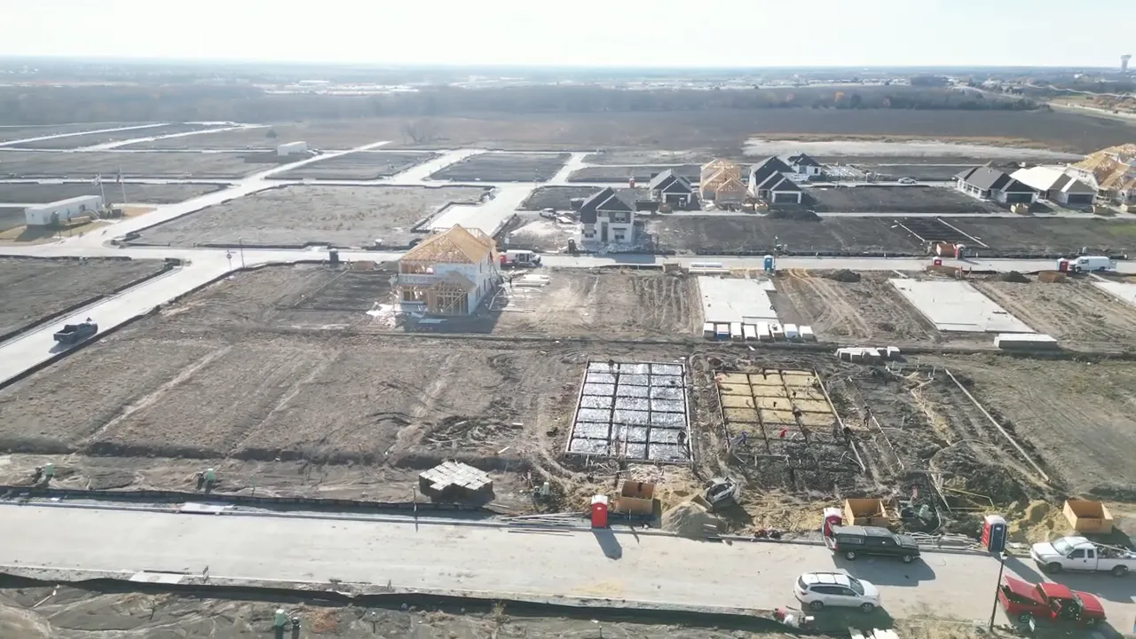 Drone view showing foundations framed homes streets and open lots