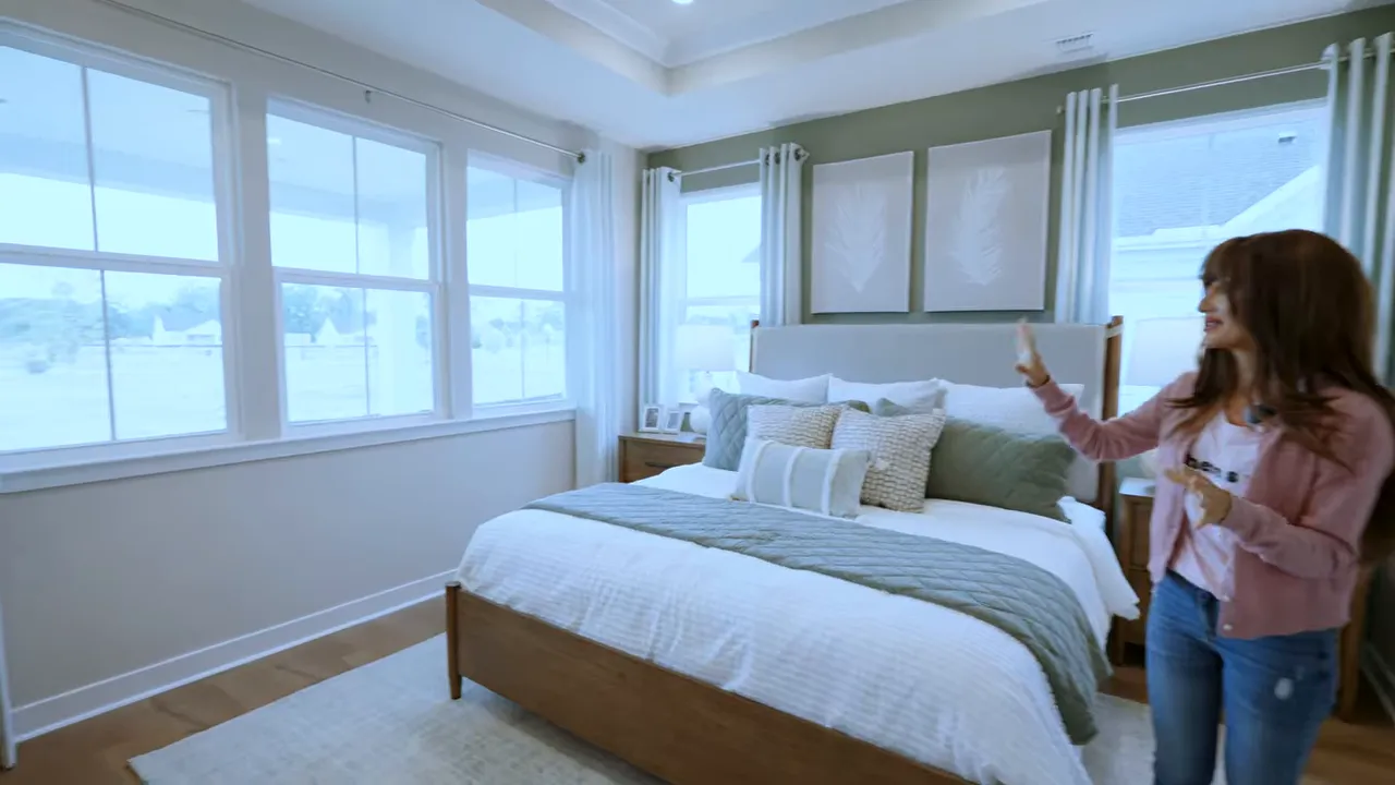 Primary suite showing wall of windows and bright, airy bedroom layout
