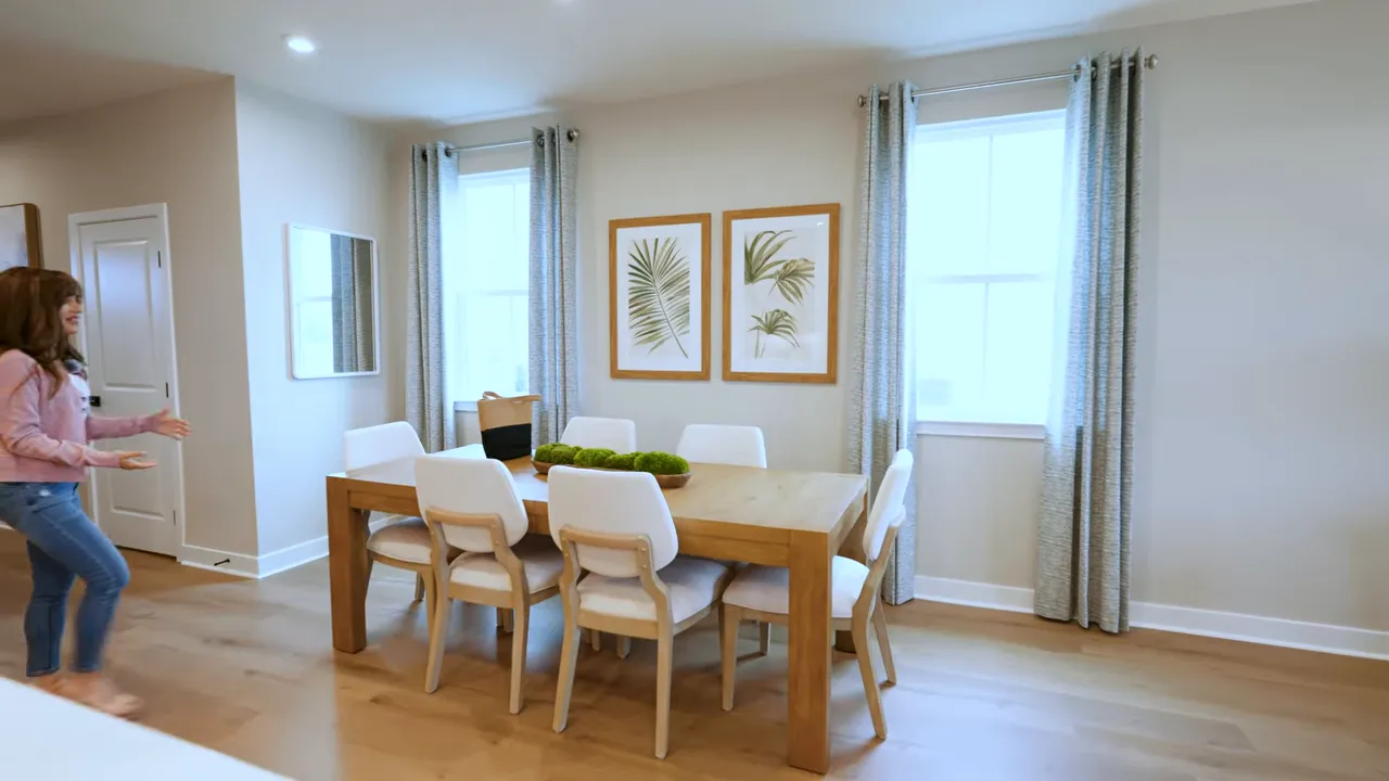 Dining room view with table seating and curtains letting in natural light