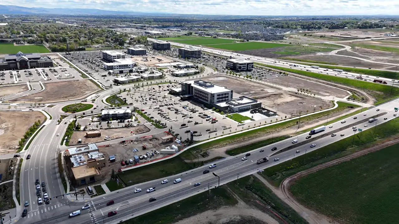 wide aerial view of a large modern development area with roads parking lots and open land around it