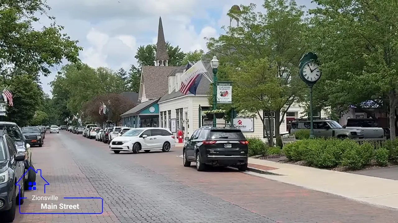 Brick Main Street in Zionsville with shops trees sidewalks and parked cars