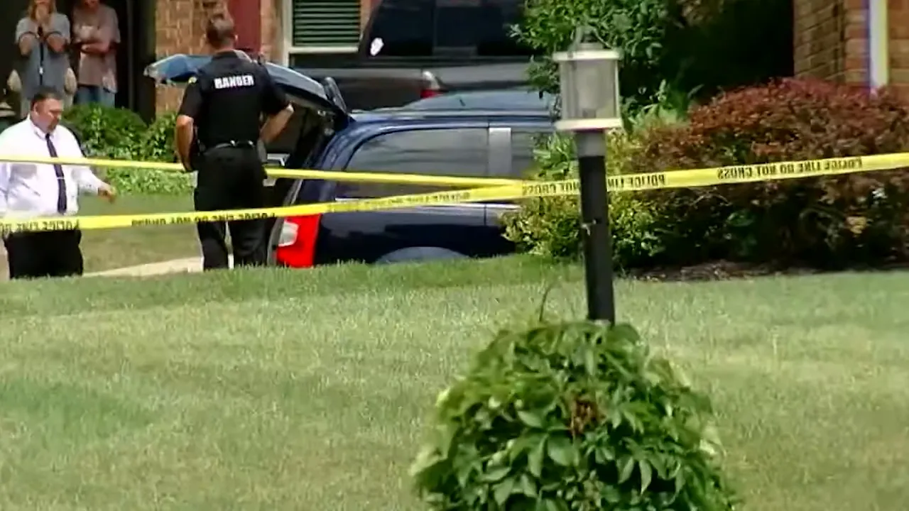 Police scene in grassy residential area with large white number 15 and 2024 text