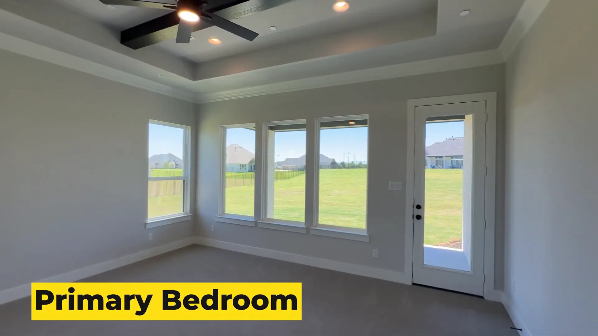 Primary bedroom with large windows and access to covered deck