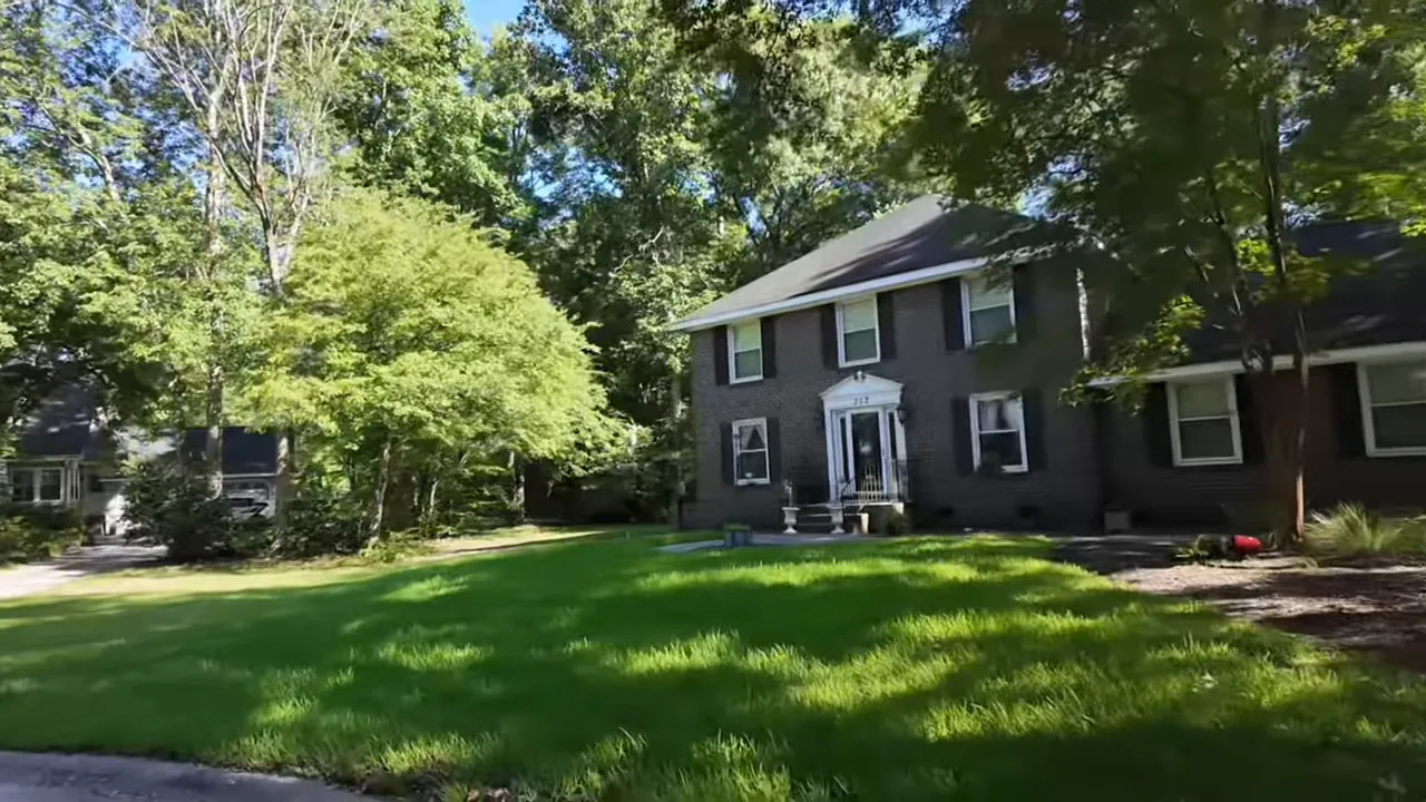 Two‑story brick colonial with a large front lawn and surrounding mature trees highlighting Ashboro's architectural character and lot size